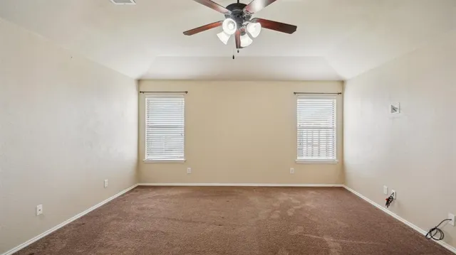 an empty room with a window and a chandelier fan