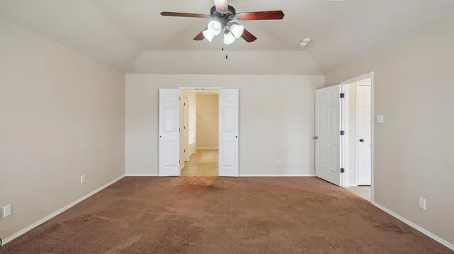 a view of an empty room with a ceiling fan