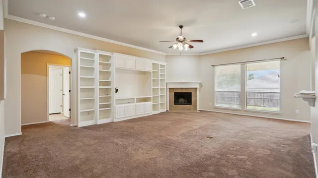 a view of an empty room with a fireplace and a window