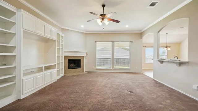 a view of an empty room with a fireplace and a window
