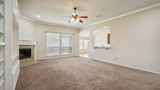 a view of an empty room with a fireplace and a window