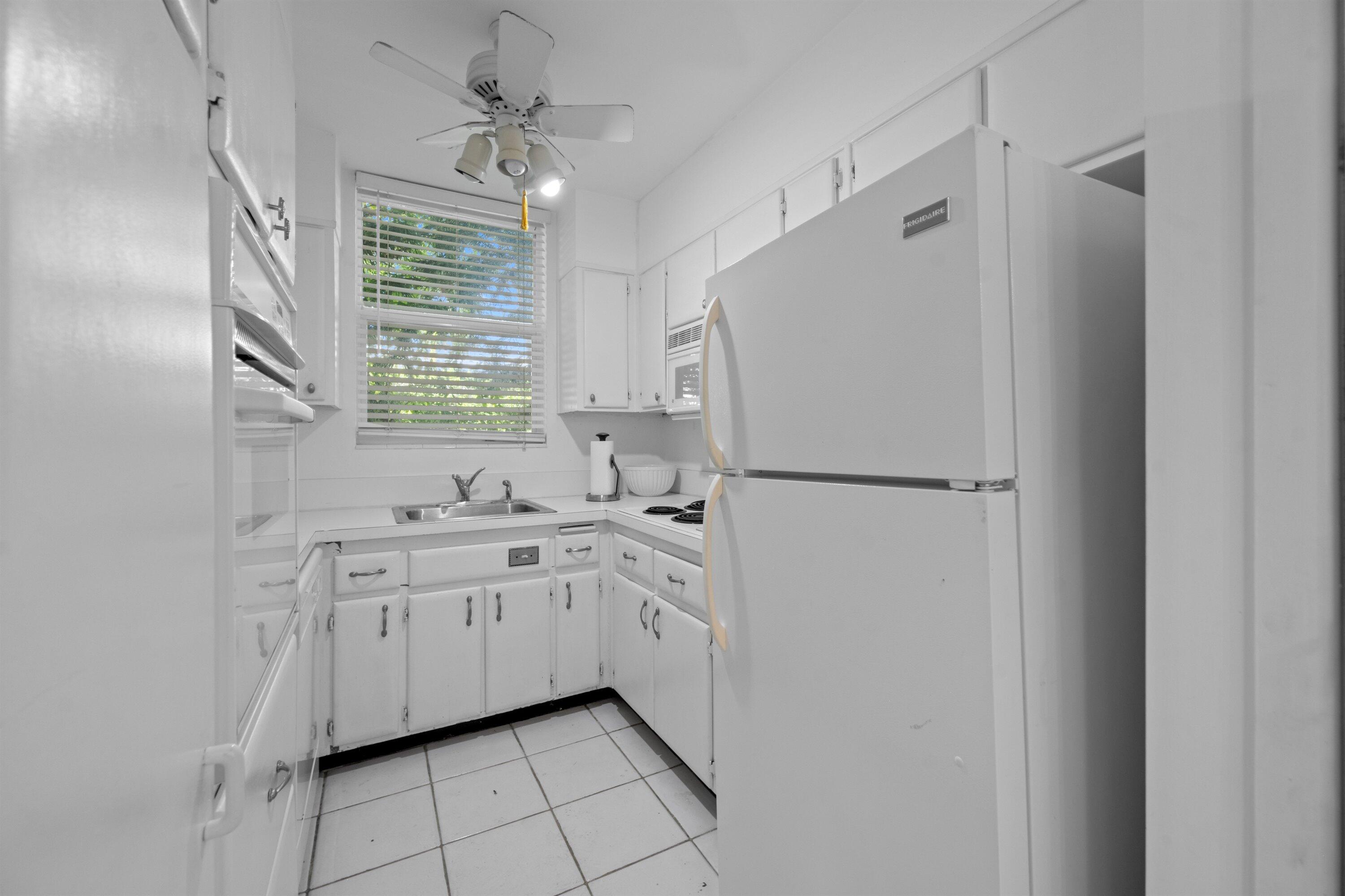 401 Peruvian Avenue, Unit 1010 Palm Beach, FL 33480 - Photo 7 of 19 a kitchen with white cabinets and white appliances