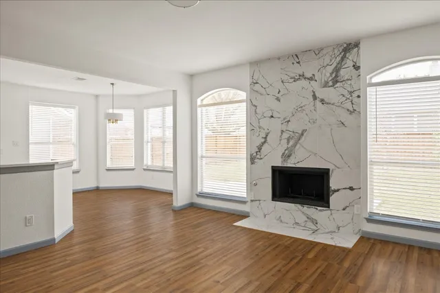 a view of a livingroom with wooden floor and a fireplace