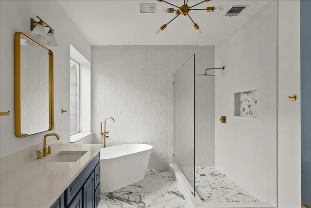 a bathroom with a tub sink and mirror