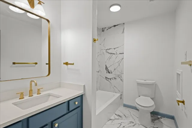 a bathroom with a granite countertop sink toilet and shower