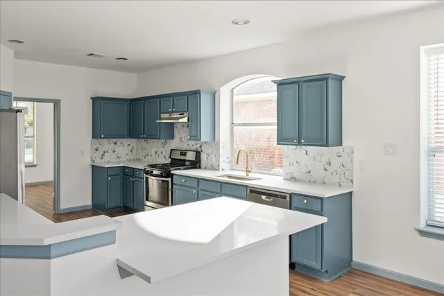 a kitchen with a sink stove and refrigerator
