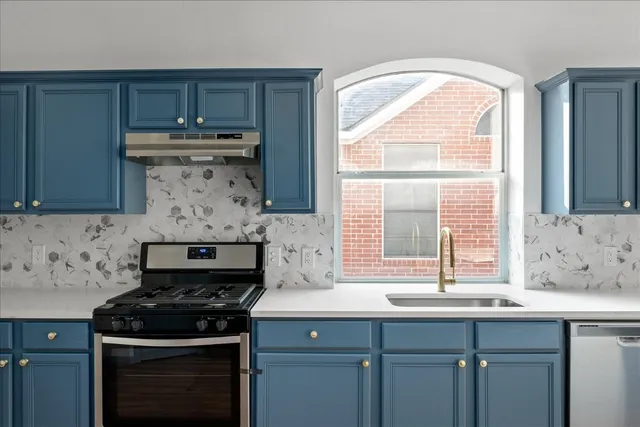 a kitchen with a sink stove top oven and cabinets
