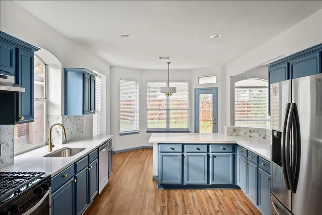 a kitchen with stainless steel appliances granite countertop a sink stove and refrigerator