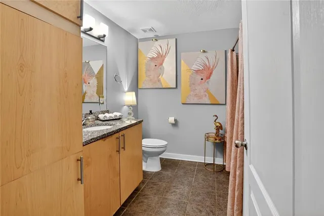 a bathroom with a granite countertop sink toilet and shower