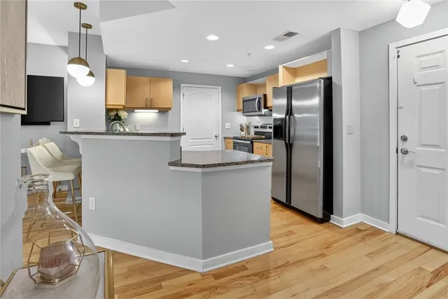 a kitchen with stainless steel appliances granite countertop a refrigerator a sink a stove a microwave and island