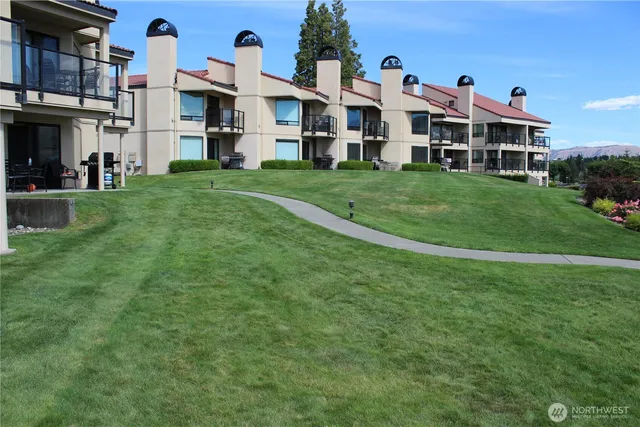 a view of a house with a yard and sitting area