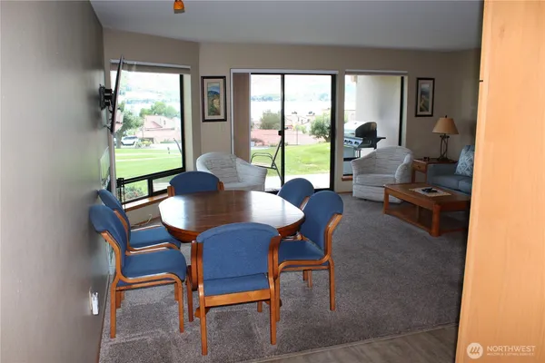 a view of a dining room with furniture large windows and wooden floor