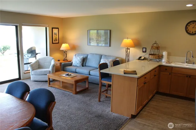 a open kitchen with stainless steel appliances kitchen island granite countertop a sink and a refrigerator