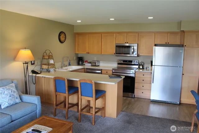 a kitchen with a refrigerator a stove top oven a sink and cabinets