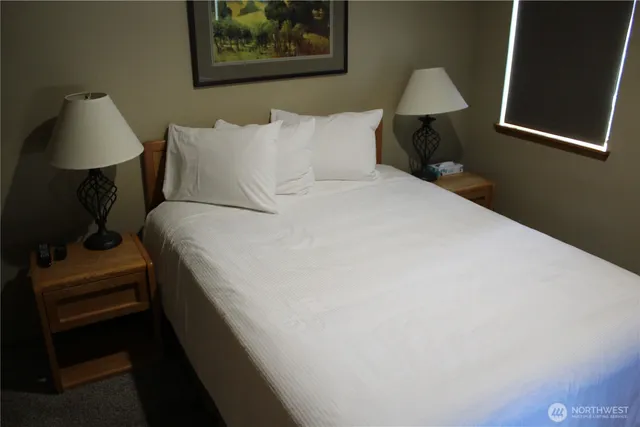 a bedroom with a bed and a lamp on table