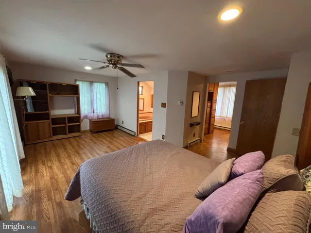 a spacious bedroom with a bed and a flat screen tv
