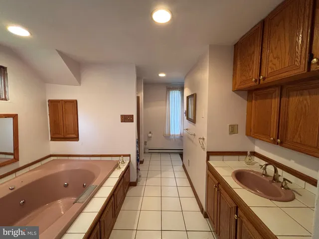 a bathroom with a tub sink and mirror