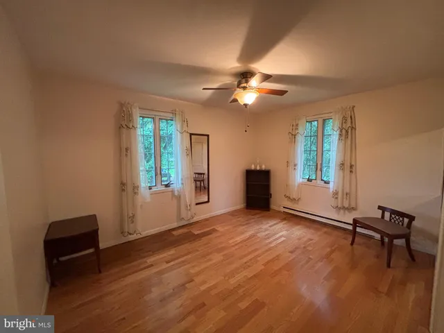 an empty room with windows and ceiling fan