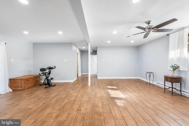 a view of a room with wooden floor and a ceiling fan