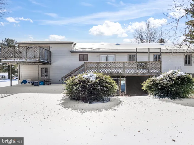 a view of a house with a yard covered in snow