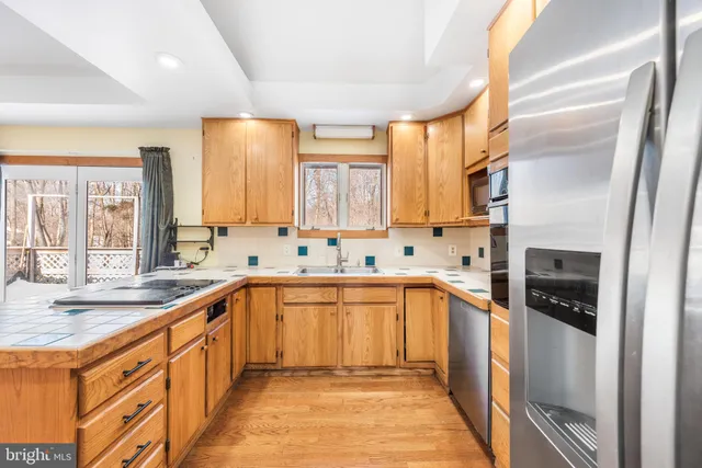 a kitchen with stainless steel appliances granite countertop a sink and a stove