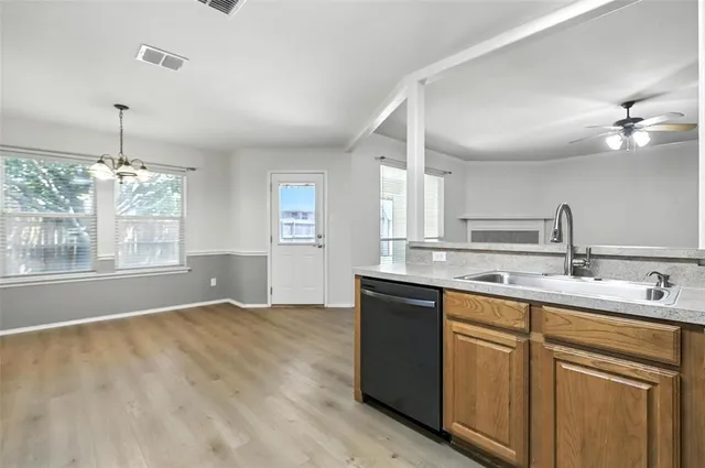 a kitchen with kitchen island granite countertop a sink cabinets and window