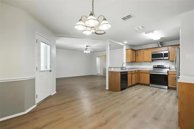 a kitchen with stainless steel appliances kitchen island a refrigerator and a stove top oven