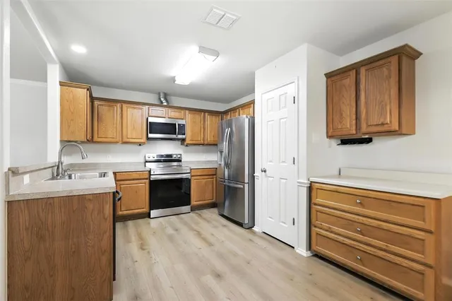a kitchen with stainless steel appliances granite countertop a refrigerator and a stove top oven