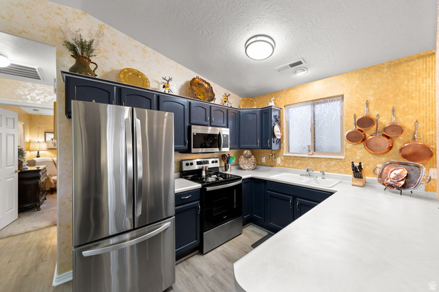 1225 North Dixie Downs Road, Unit 161 St. George, UT 84770 - Photo 10 of 21 Kitchen featuring dark cabinetry with light countertops, stainless steel appliances, and wood-finish flooring