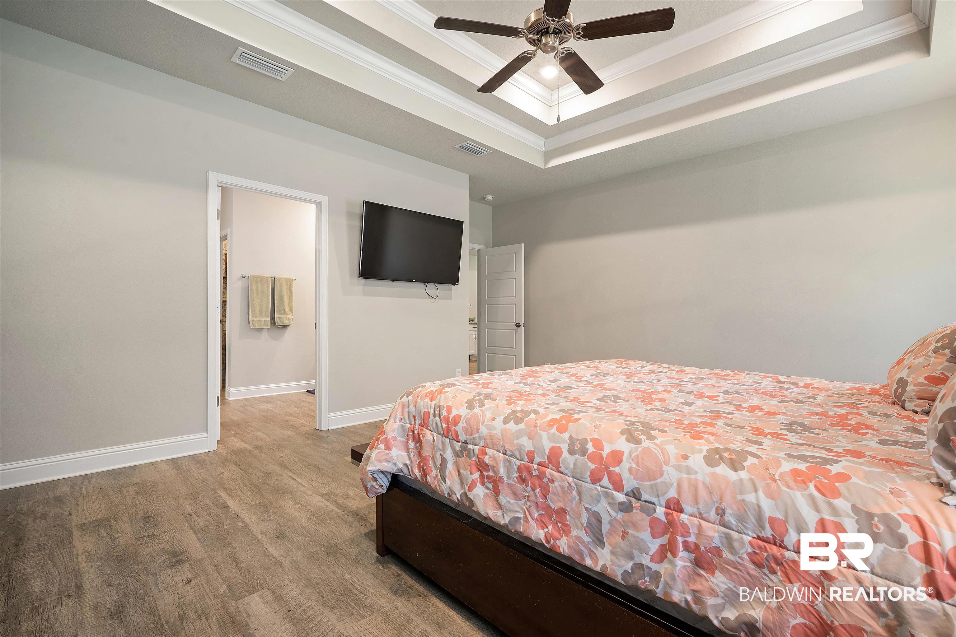 1700 Gwin Court Mobile, AL 36695 - Photo 18 of 36 Bedroom featuring crown molding, light wood finished floors, a raised ceiling, and a ceiling fan