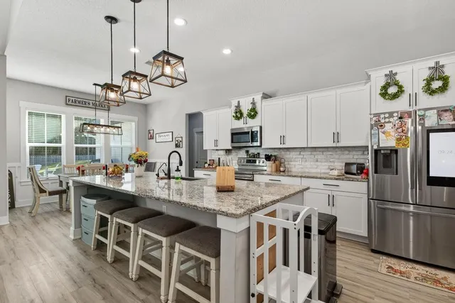 a kitchen with stainless steel appliances kitchen island granite countertop a sink and cabinets