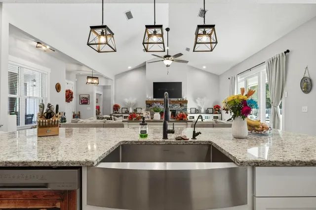 a bedroom with a large bed couch and windows