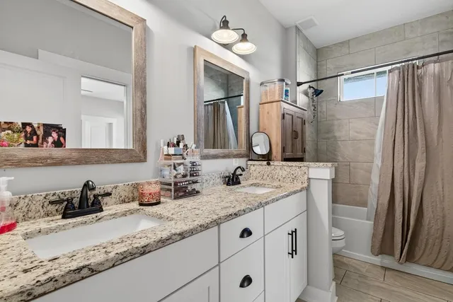 a bathroom with a granite countertop sink a vanity and a mirror