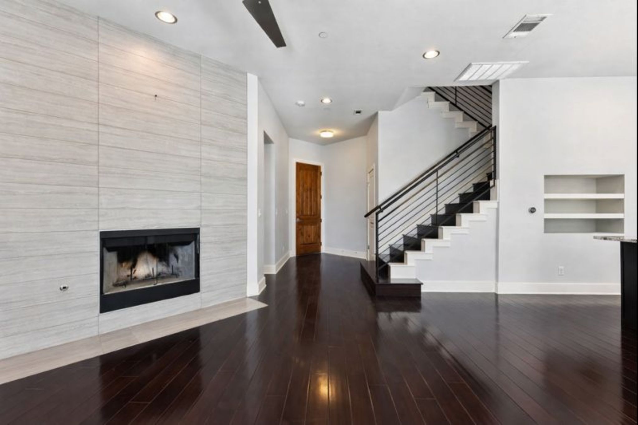 8110 Ranch Road 2222, Unit 98 Austin, TX 78730 - Photo 8 of 37 Unfurnished living room with a fireplace, stairway, recessed lighting, dark wood-style floors, and built in shelves