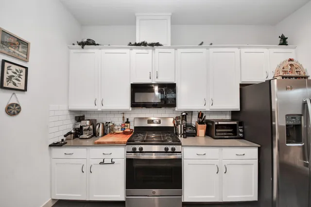 a kitchen with appliances a sink and cabinets