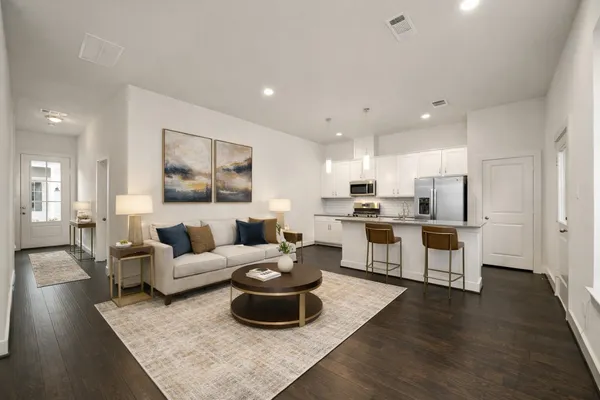 a living room with furniture and view of kitchen