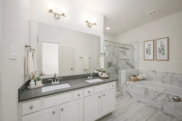 a bathroom with double vanity sinks a mirror and a shower