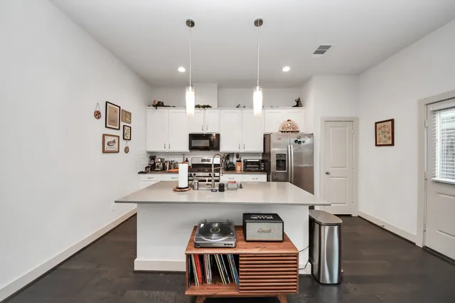 a kitchen with stainless steel appliances granite countertop a sink refrigerator and cabinets