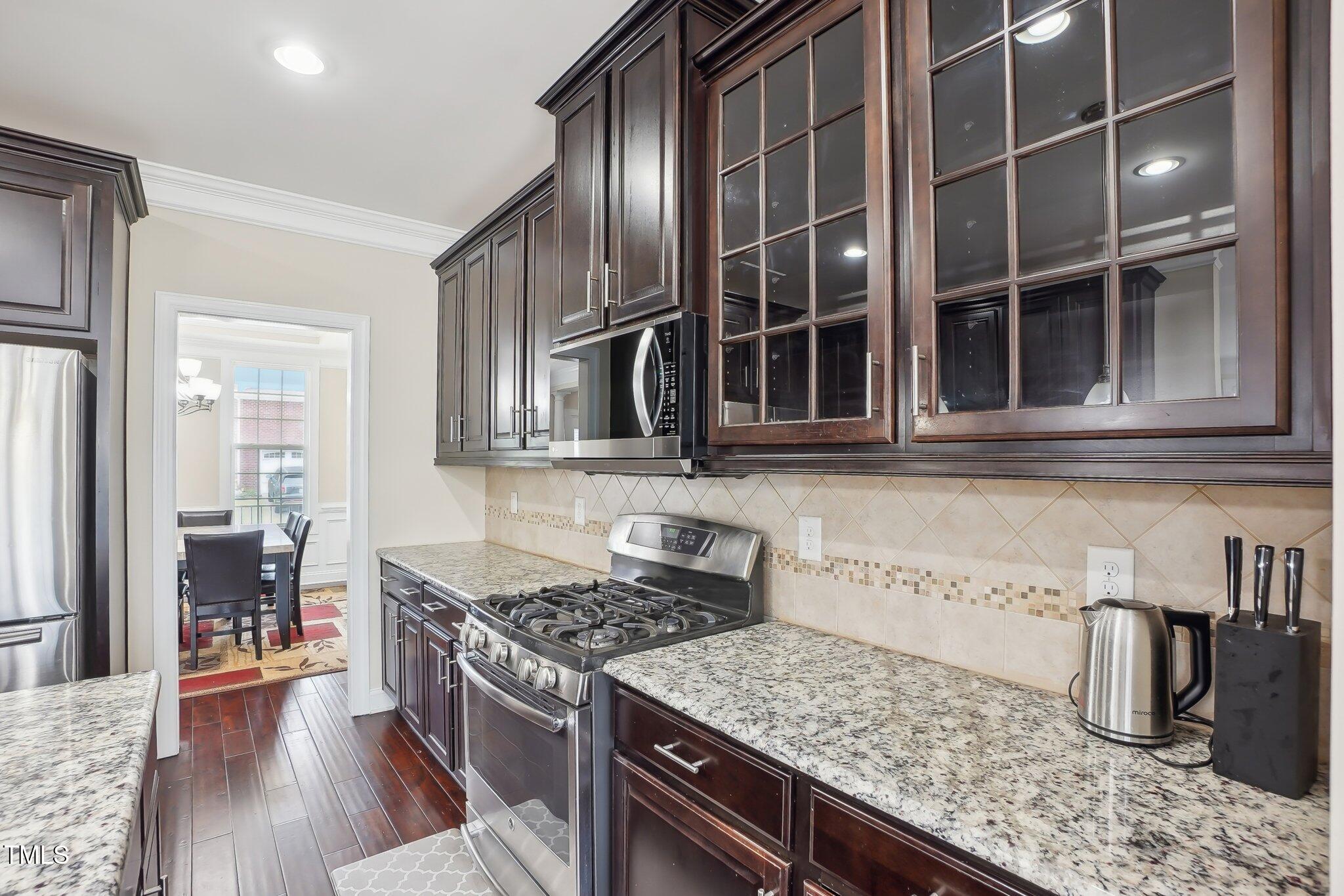 4008 Sykes Street Cary, NC 27519 - Photo 8 of 41 a kitchen with granite countertop a stove and a sink