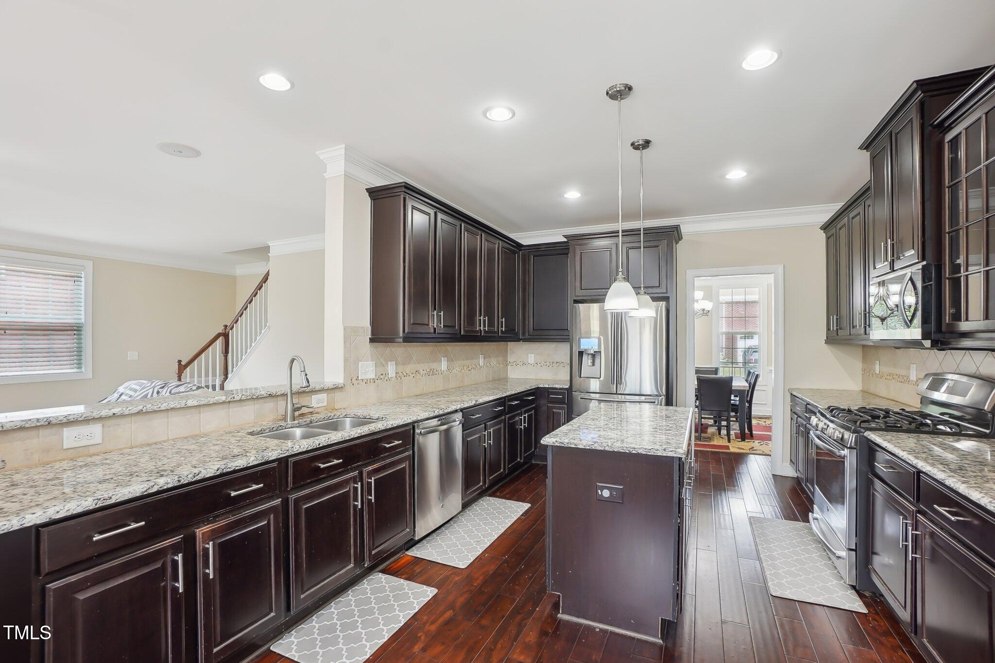4008 Sykes Street Cary, NC 27519 - Photo 11 of 41 a large kitchen with stainless steel appliances granite countertop plenty wooden cabinets counter space and wooden floor