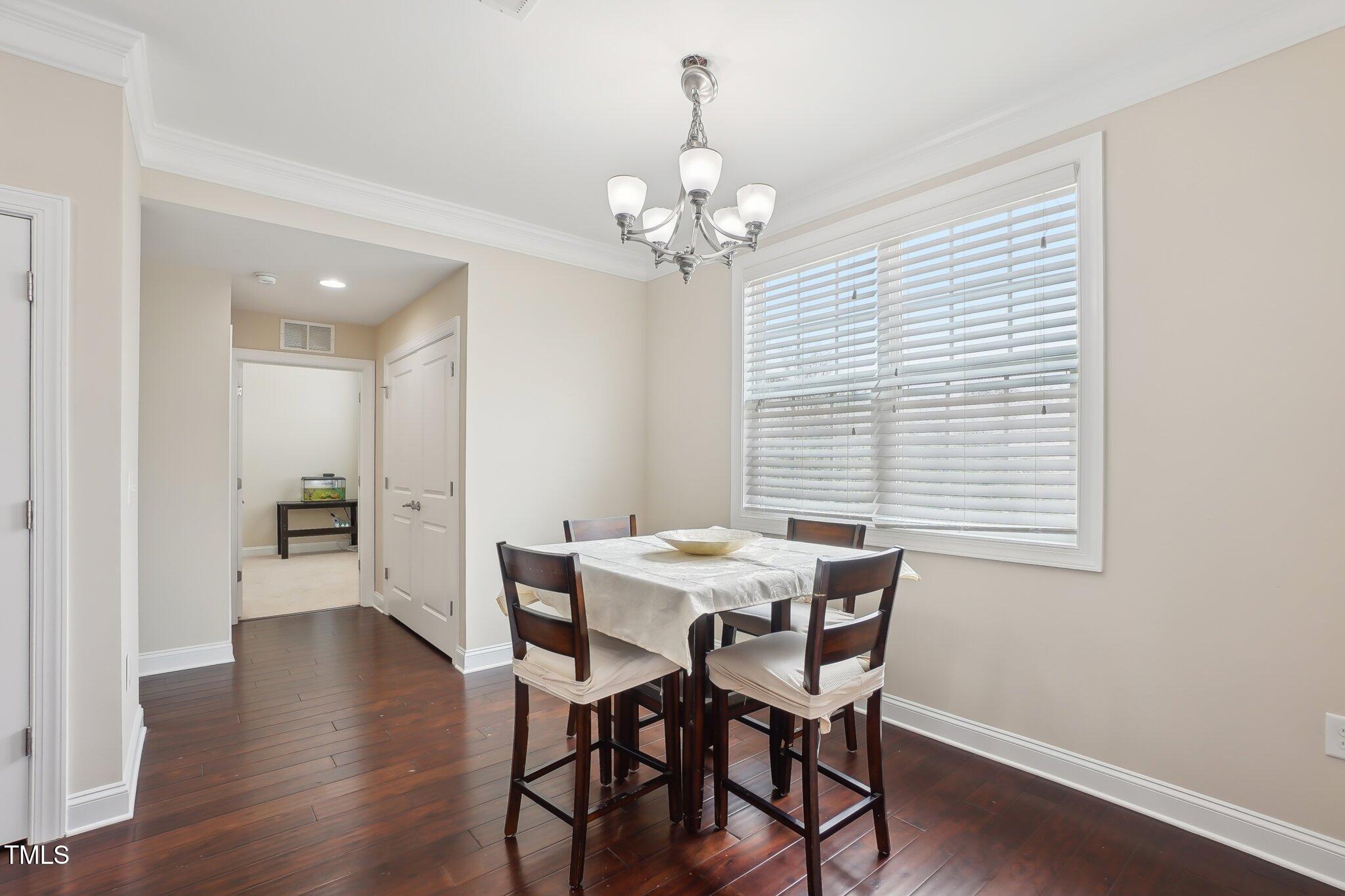 4008 Sykes Street Cary, NC 27519 - Photo 15 of 41 a view of a dining room with furniture wooden floor and chandelier