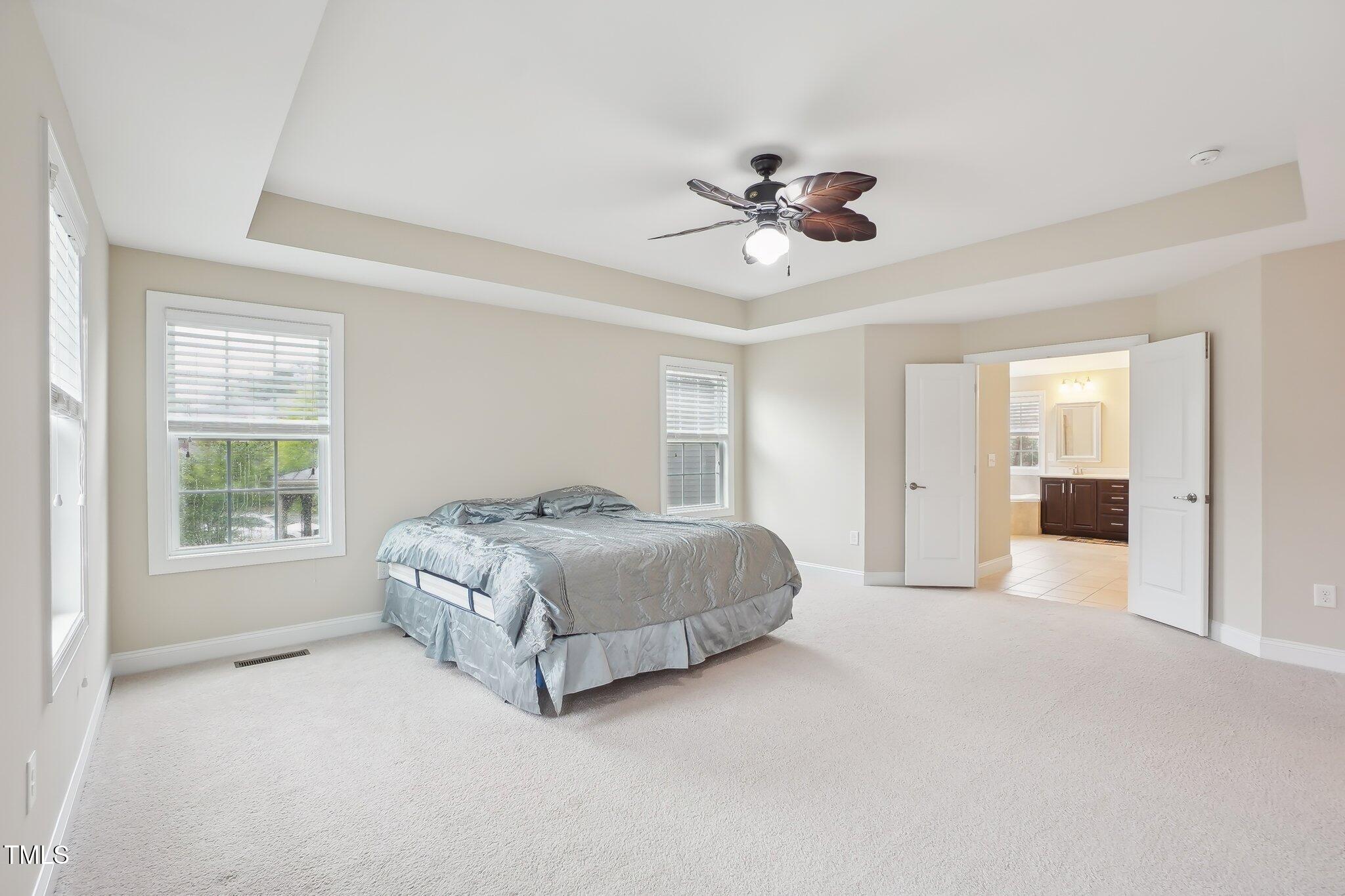 4008 Sykes Street Cary, NC 27519 - Photo 18 of 41 a spacious bedroom with a large bed and ceiling fan