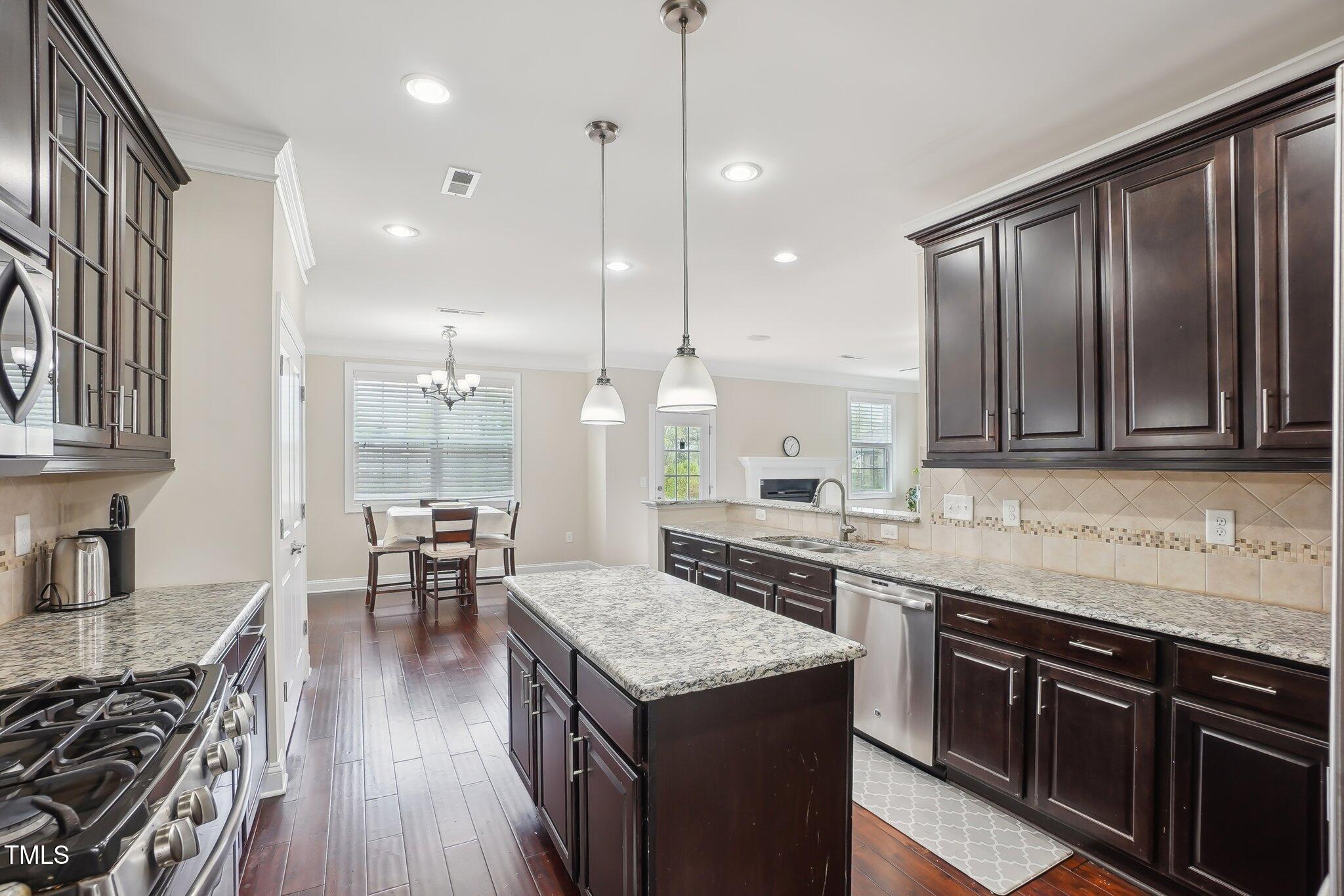 4008 Sykes Street Cary, NC 27519 - Photo 7 of 41 a kitchen with a stove sink cabinets and wooden floor