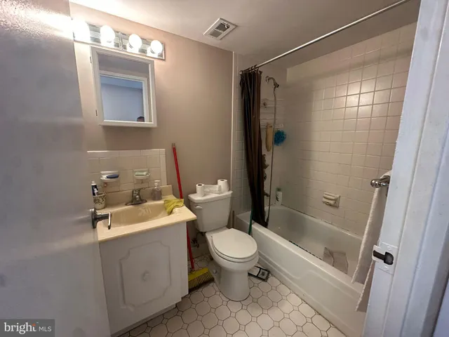 a bathroom with a sink and mirror with bathtub