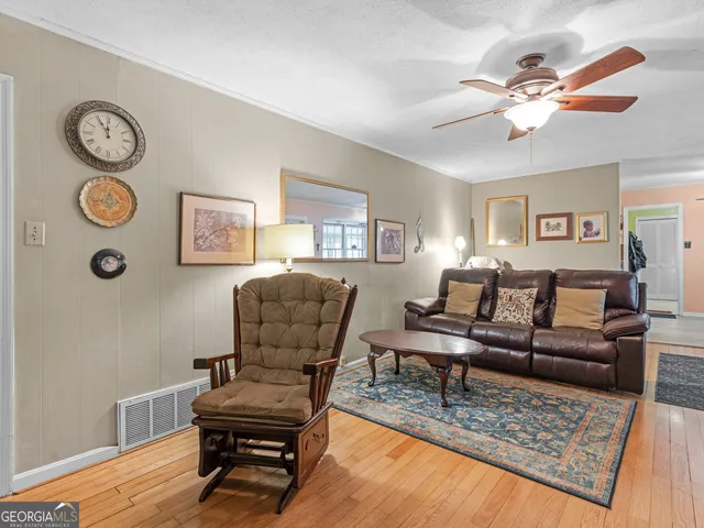 an empty room with windows and fan view