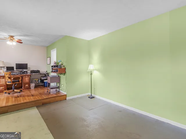 a view of a workspace with furniture and a window
