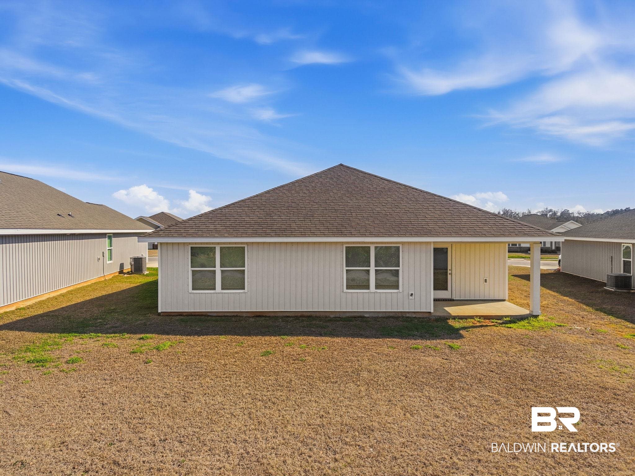 23952 Citation Loop Daphne, AL 36526 - Photo 37 of 69 Rear view of house featuring a shingled roof, a patio area, and a lawn