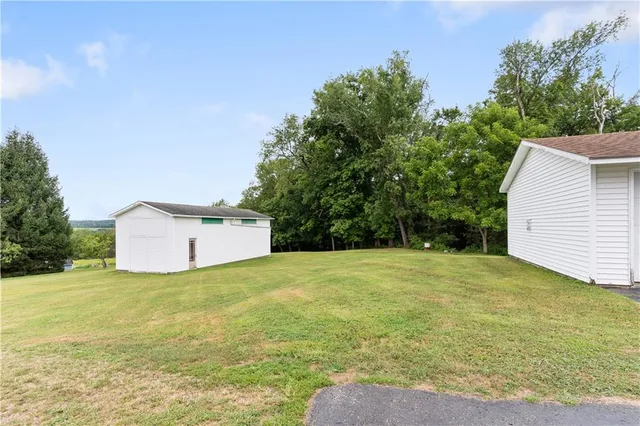 a view of a big yard with an trees and fence