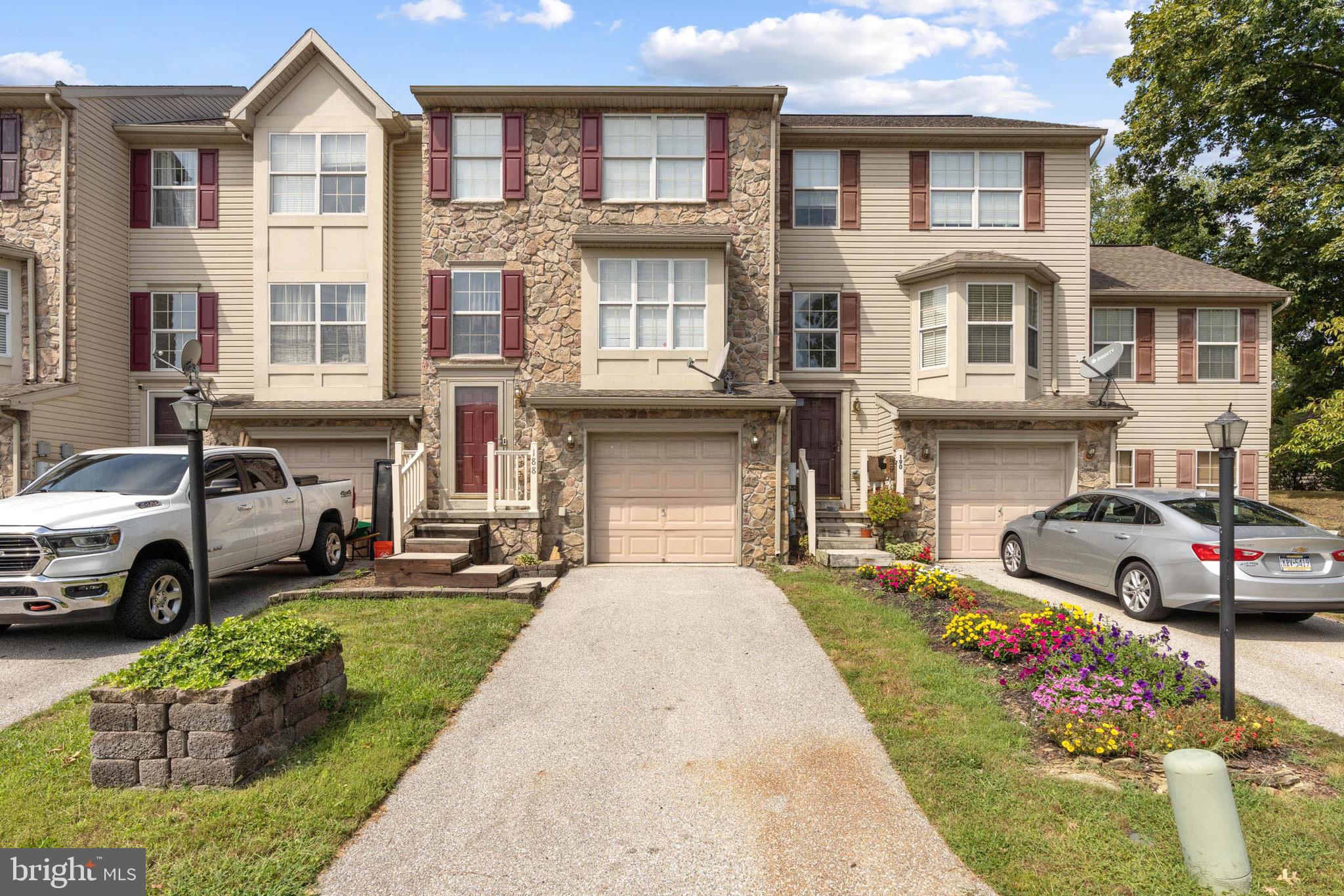 a front view of a house with a garden and parking space