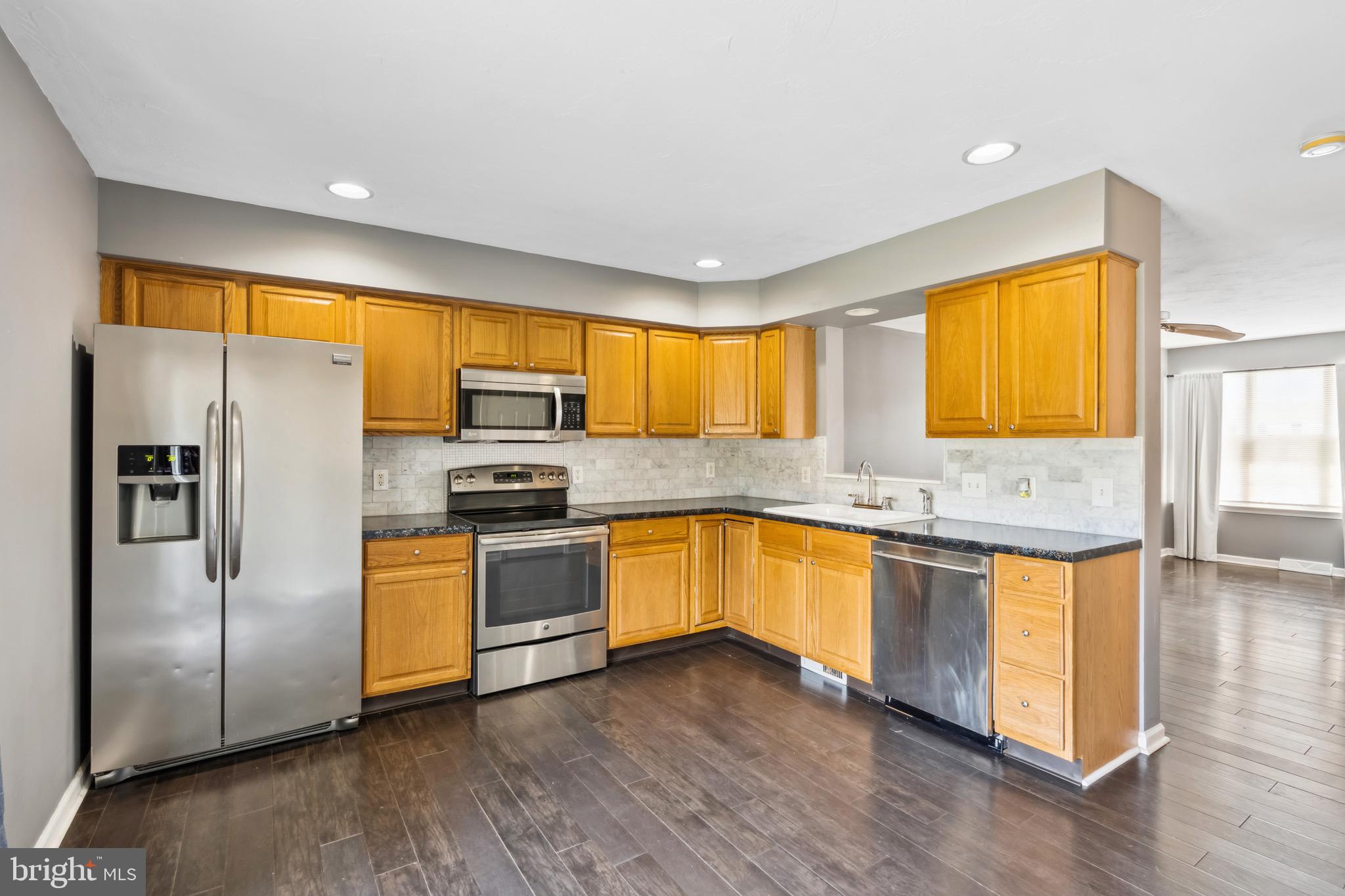 188 Sara Lane Hanover, PA 17331 - Photo 5 of 25 a kitchen with stainless steel appliances granite countertop a refrigerator a sink dishwasher a stove and a sink with wooden floor
